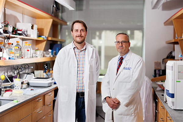 Dr. Michael Plebanek and Dr. Brent Hanks standing in lab.