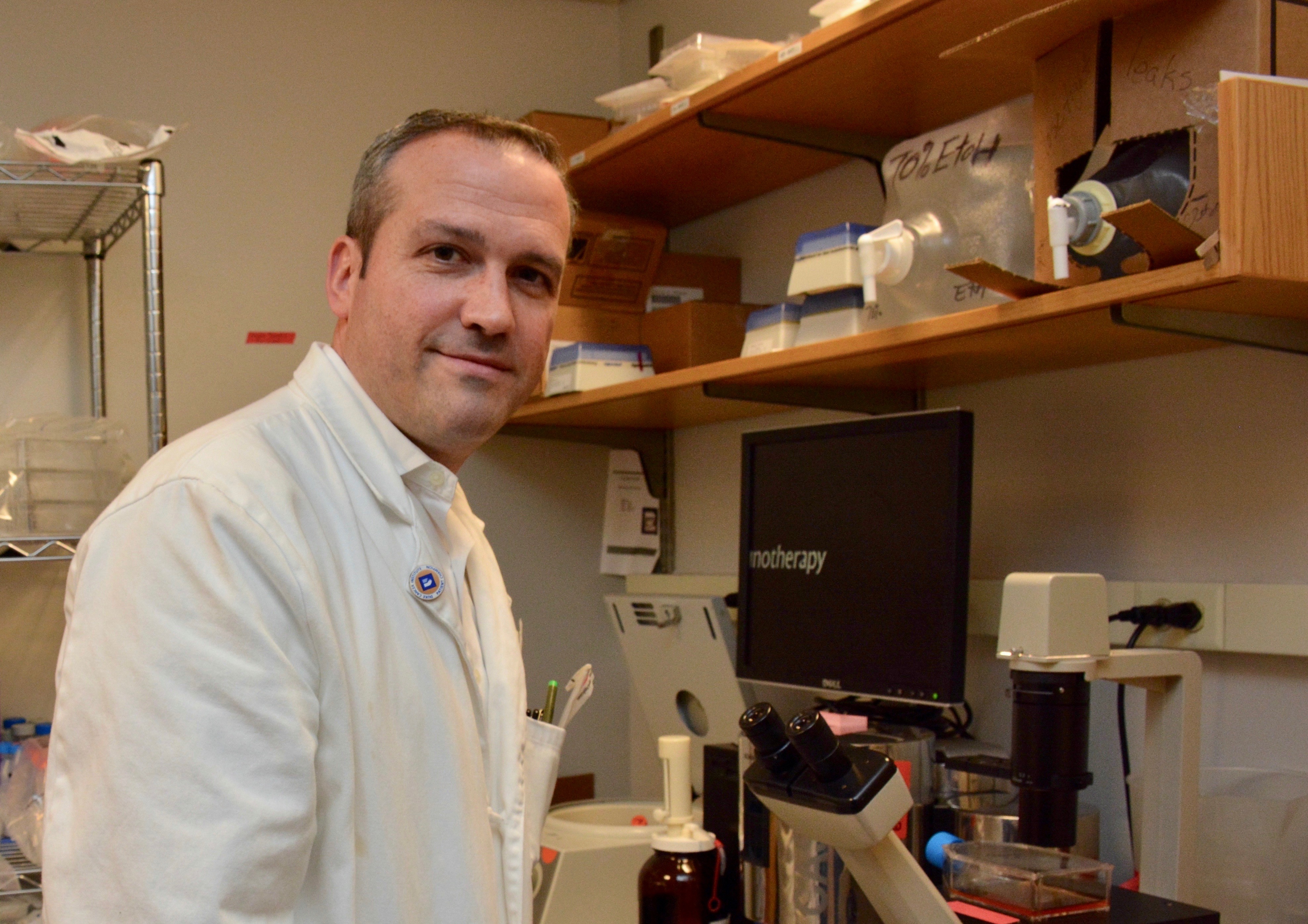 Dr. Brent Hanks standing and smiling in lab.